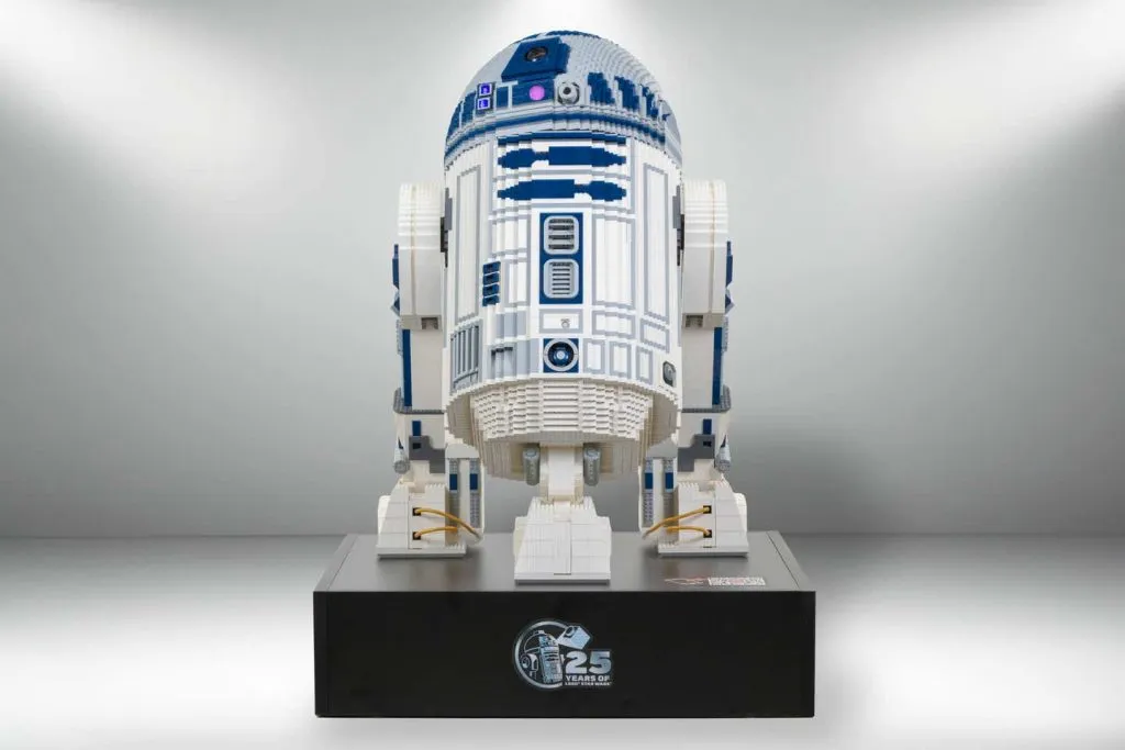 R2-D2 exibido em um estande com o logotipo do 25º aniversário do LEGO Star Wars.