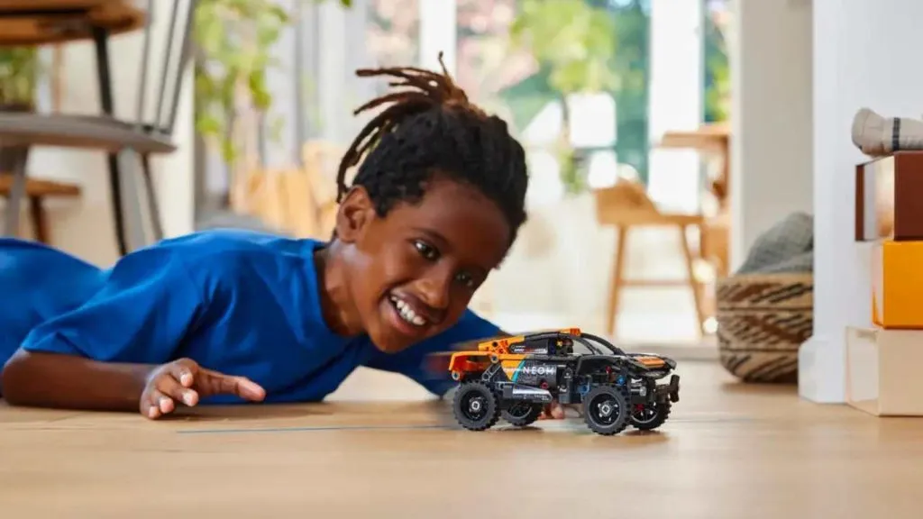 Un bambino che gioca con l'auto da corsa LEGO Technic NEOM McLaren Extreme E