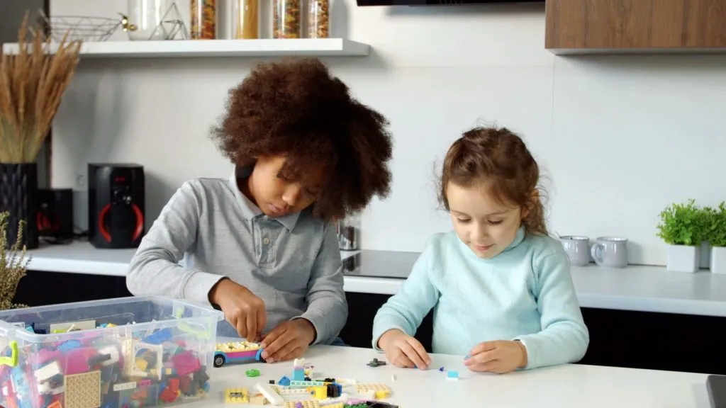 Due bambini che giocano con i mattoncini LEGO