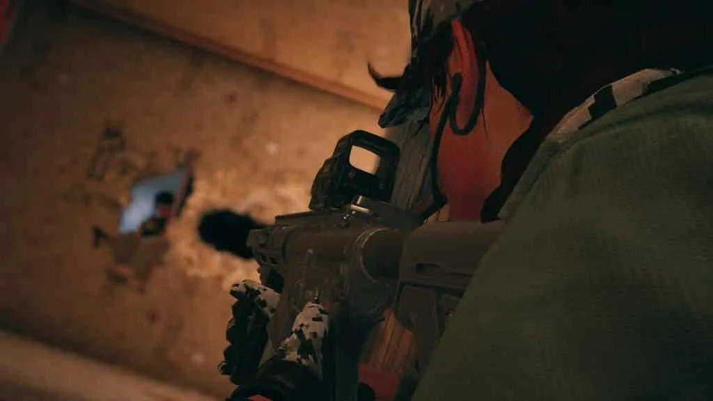 Das Bild von Rainbow Six Siege zeigt einen Operator, der durch eine Wand schießt