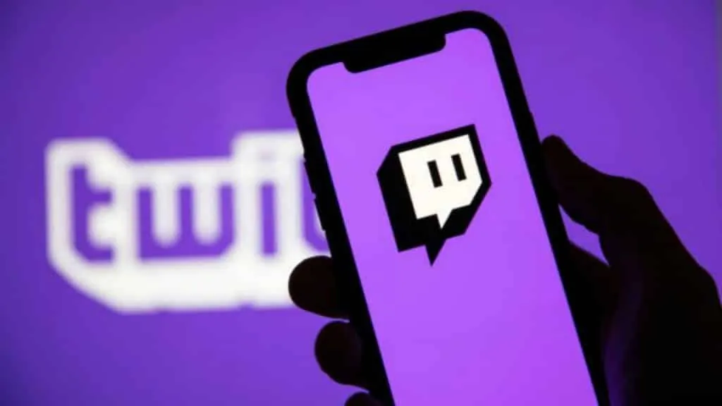 logo twitch na telefonie z logo tekstowym za nim na ekranie