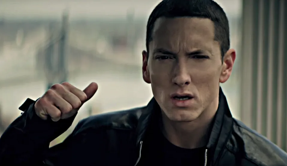 Eminem mit erhobener rechter Hand und Blick in die Kamera