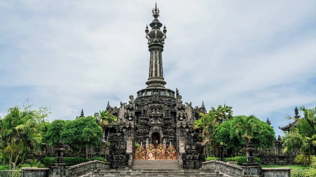 Una fotografía muestra el hito indonesio, Kawasan Lapangan Puputan Margarana, Niti Mandala Denpasar. Es un gran templo con una aguja y puertas hechas de metales de colores brillantes.