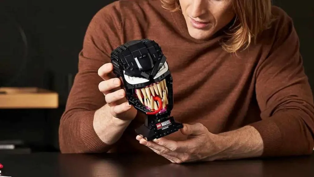 Un adulte avec son ensemble LEGO Spider-Man Venom.