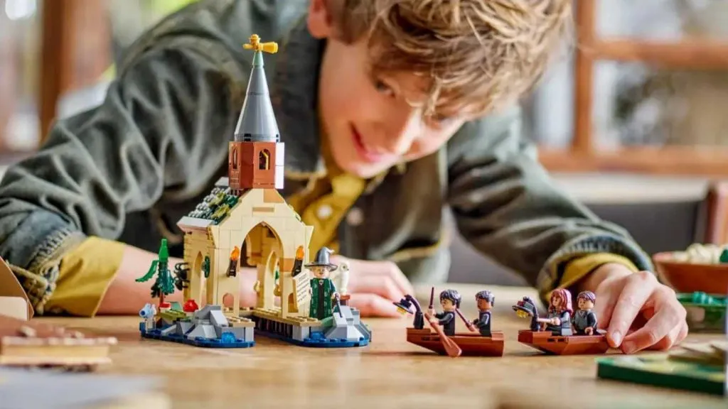 Un enfant jouant avec l'ensemble LEGO Harry Potter Le hangar à bateaux du château de Poudlard