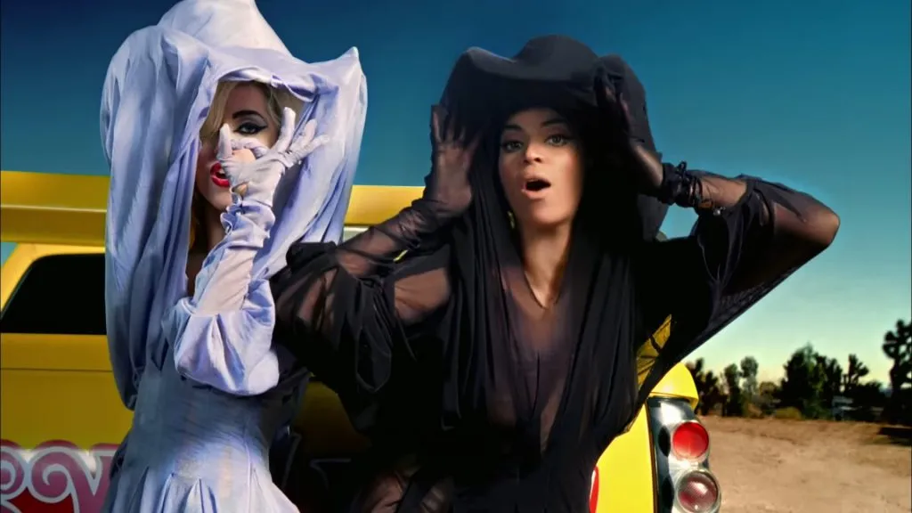 Beyoncé et Lady Gaga portant des costumes en dentelle et debout dans le désert