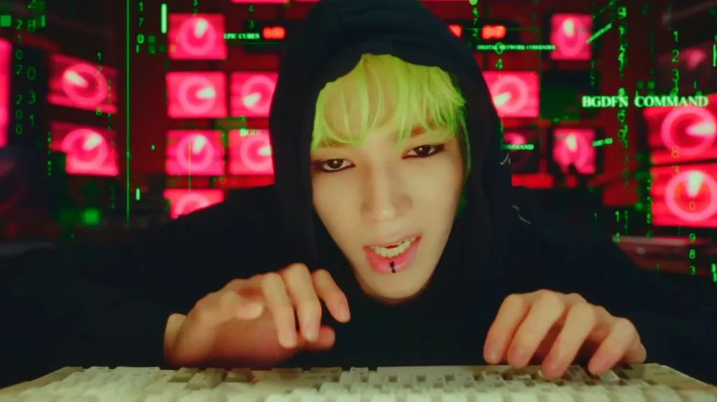 Taeyong aux cheveux verts et portant un sweat à capuche noir dans sa vidéo 'SHALALA'