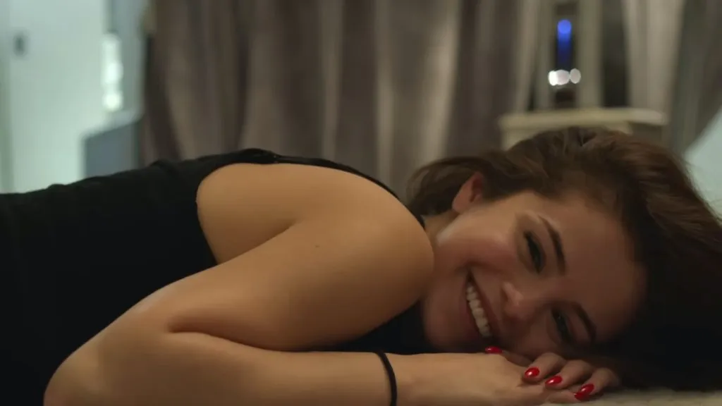 Selena Gomez sonriendo mientras está acostada en una cama