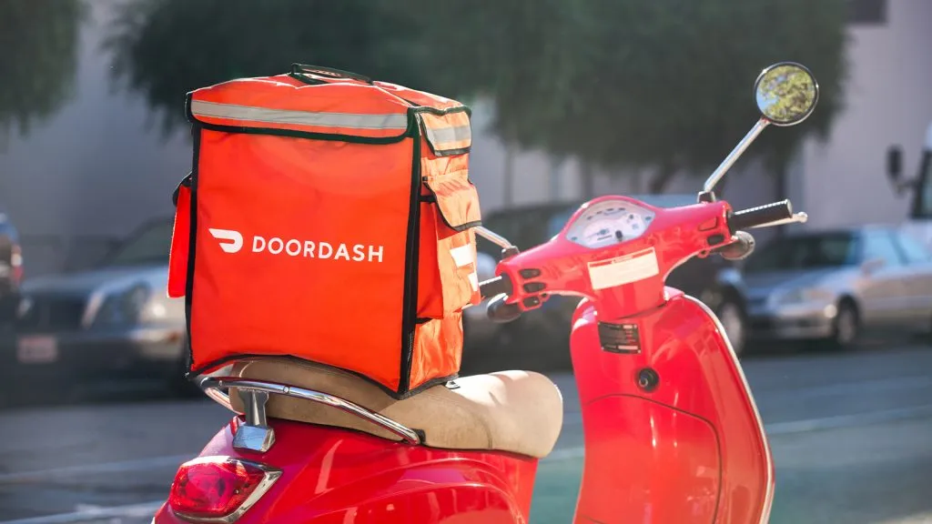 Uma scooter vermelha com uma bolsa DoorDash no assento