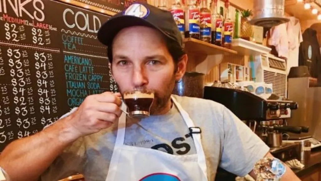 Paul Rudd bebendo um café com uniforme da Samuel's Sweet Shop