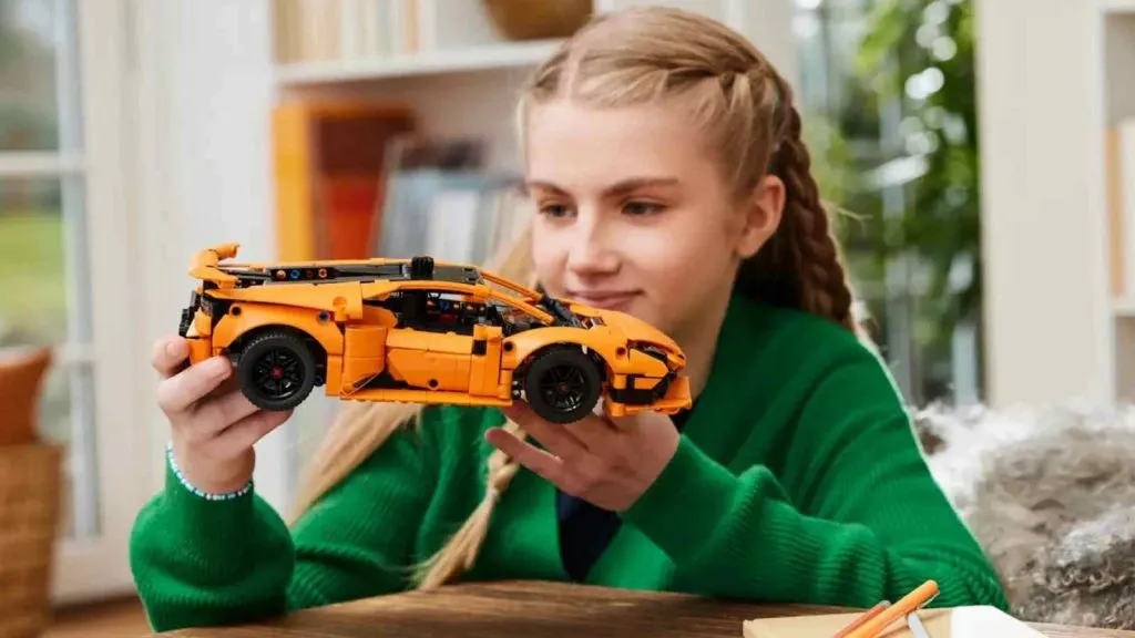 Ein Kind mit seinem orangefarbenen LEGO Technic Lamborghini Huracán-Set