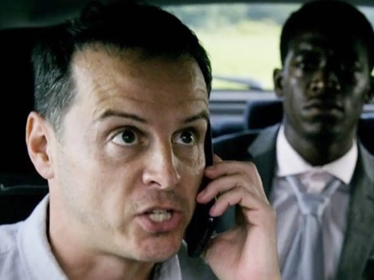 A man urgently holds a phone while another man sits in the backseat