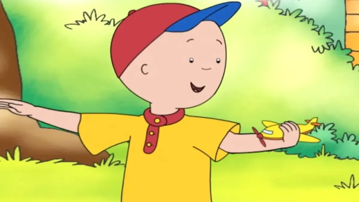 Four year old Caillou smiles and gestures in the woods in