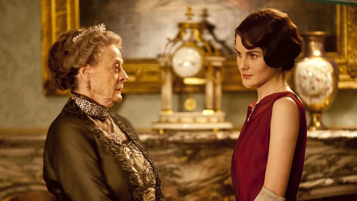 Violet talking to Mary in front of an ornate clock