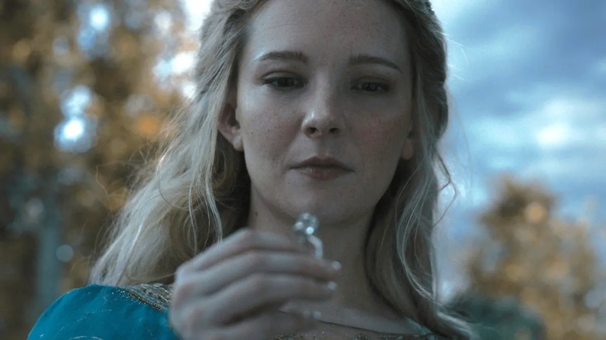 Morfydd Clark como Galadriel, olhando atentamente para um anel.