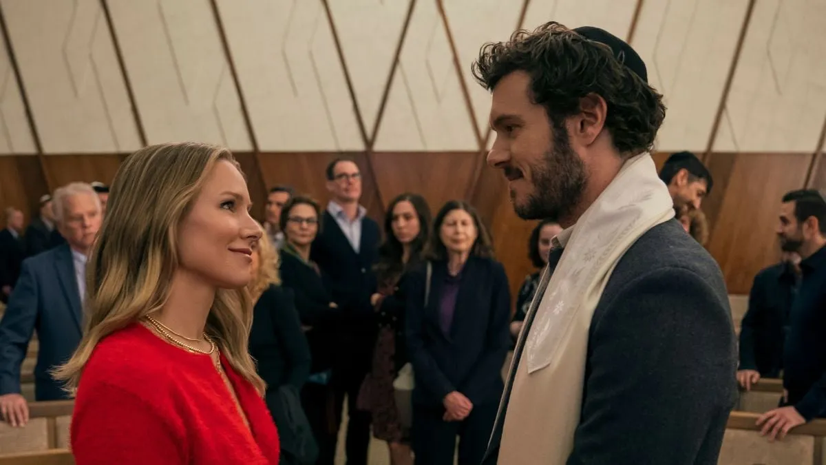 Kristen Bell dans le rôle de Joanne et Adam Brody dans le rôle du rabbin Noah se regardent dans une scène de Nobody Wants This sur Netflix