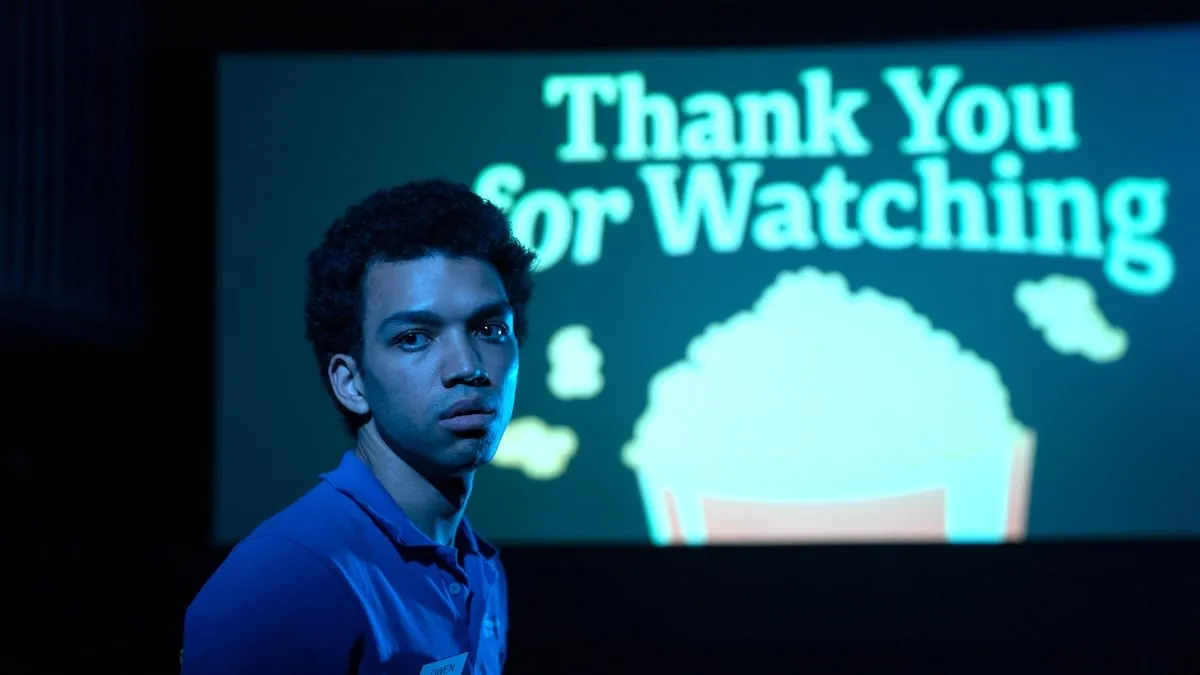 Owen (juge Smith) se tient devant un écran de cinéma sur lequel est écrit