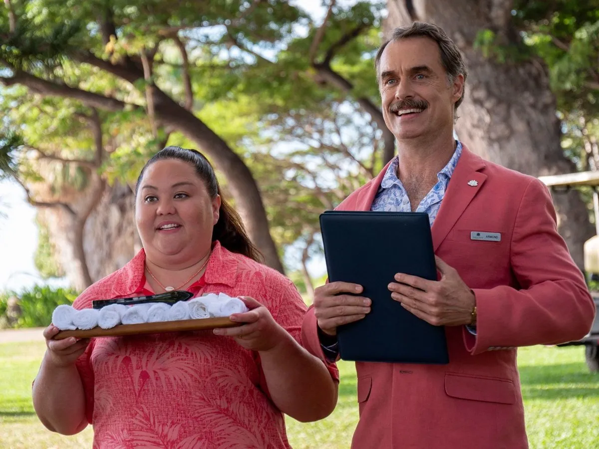 Two hospitality staff cheerfully hold clipboards in 'The White Lotus' season 1