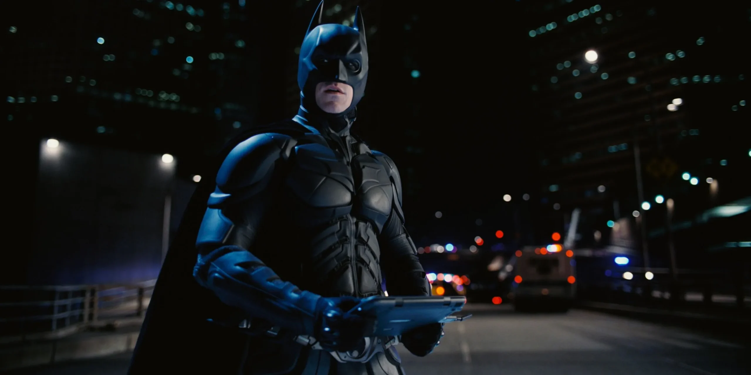 Christian Bale dans le rôle de Batman avec un ordinateur portable