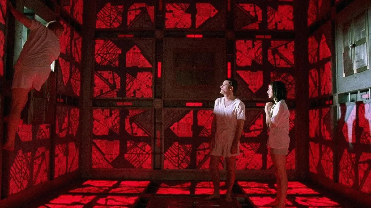 A scene from 'Cube' featuring two individuals within a giant red cube