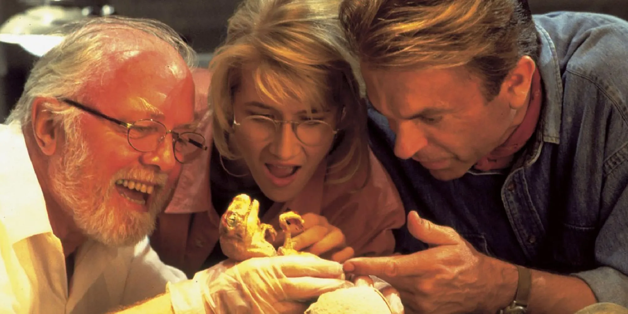 Sam Neill, Laura Dern e Richard Attenborough com um bebê dinossauro em Jurassic Park