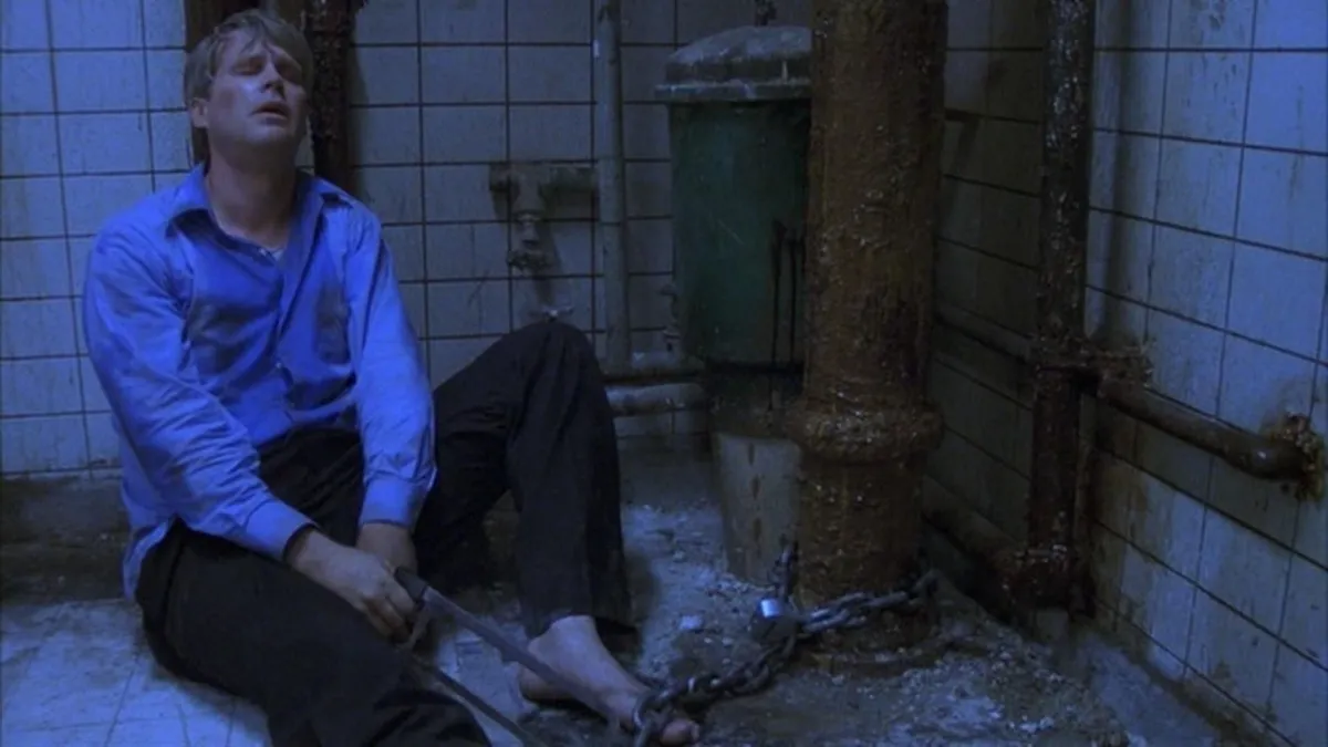 A distressed man chained in a bathroom in