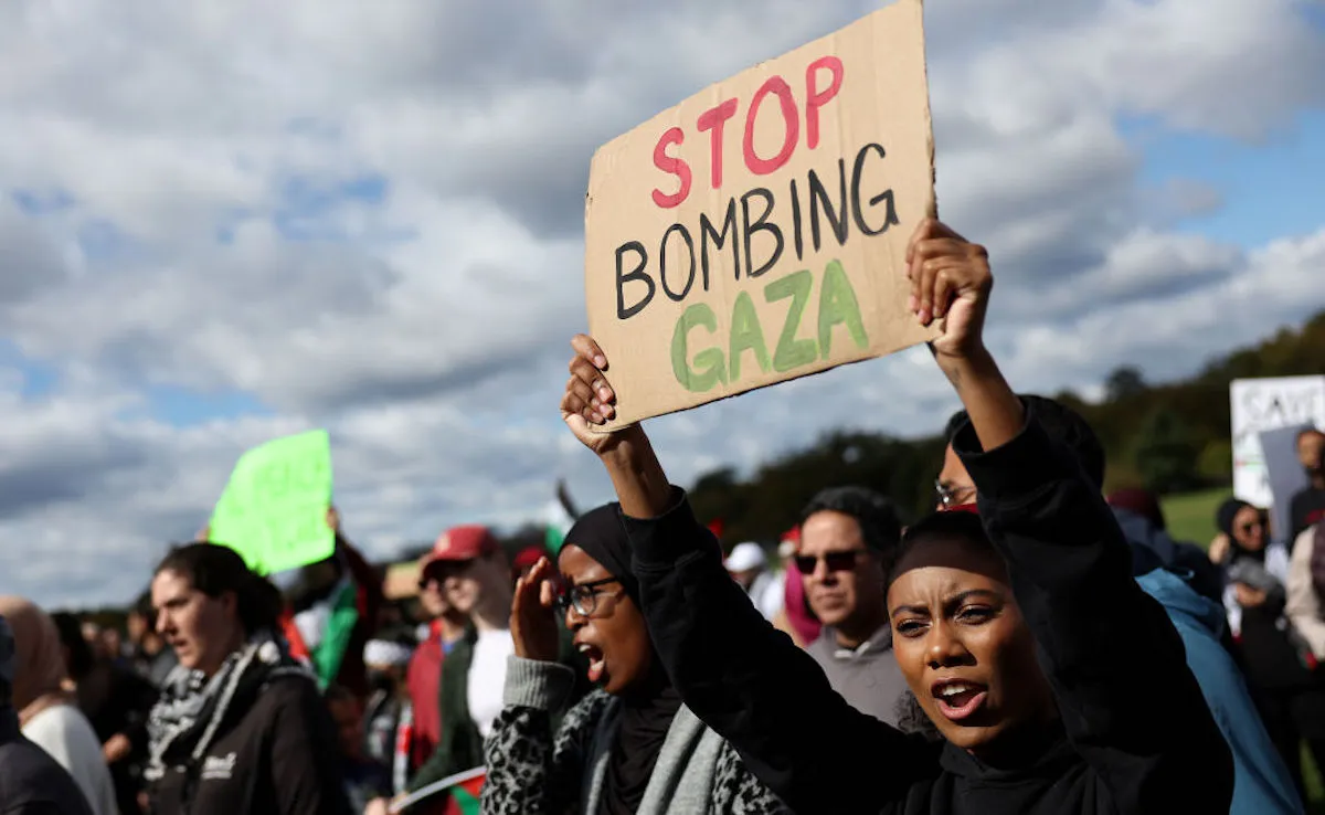 A protestor holding a sign stating