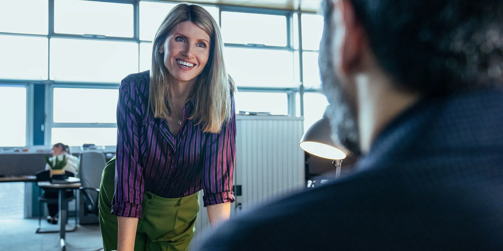 Bad Sisters에서 테이블 위에 미소 짓는 Sharon Horgan