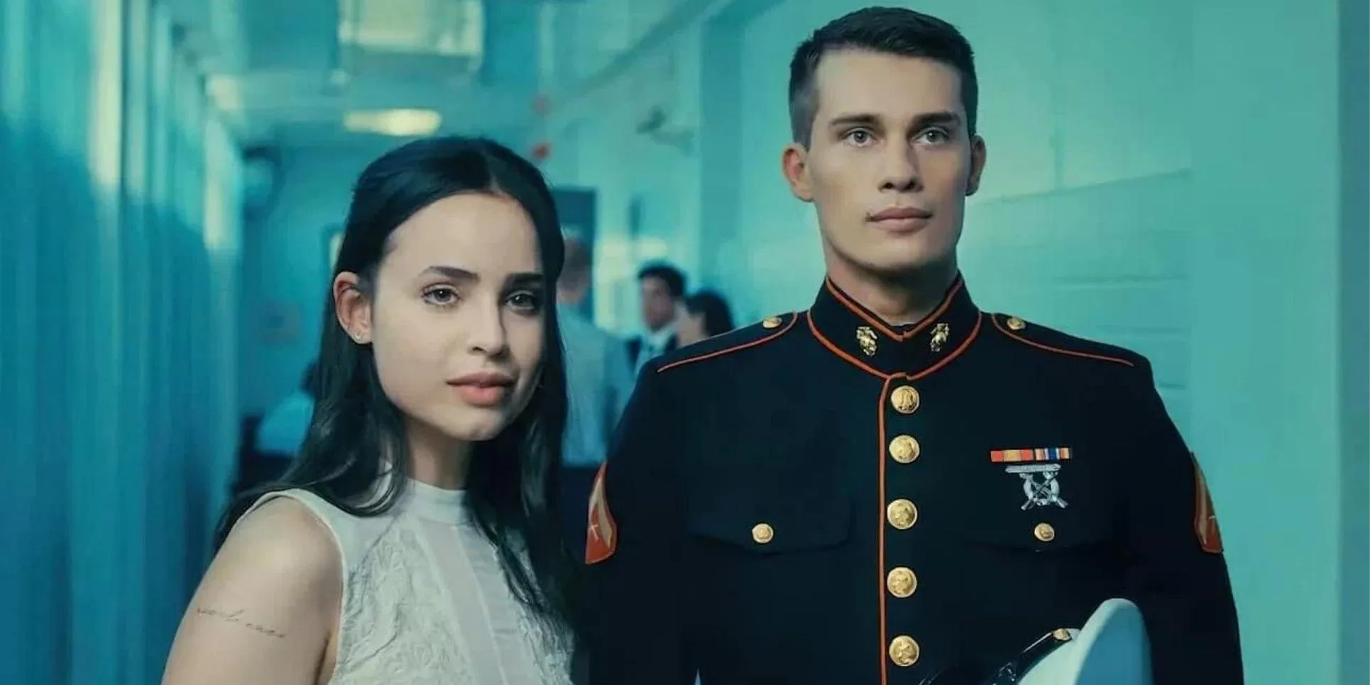 A young woman standing next to a soldier in Purple Hearts.