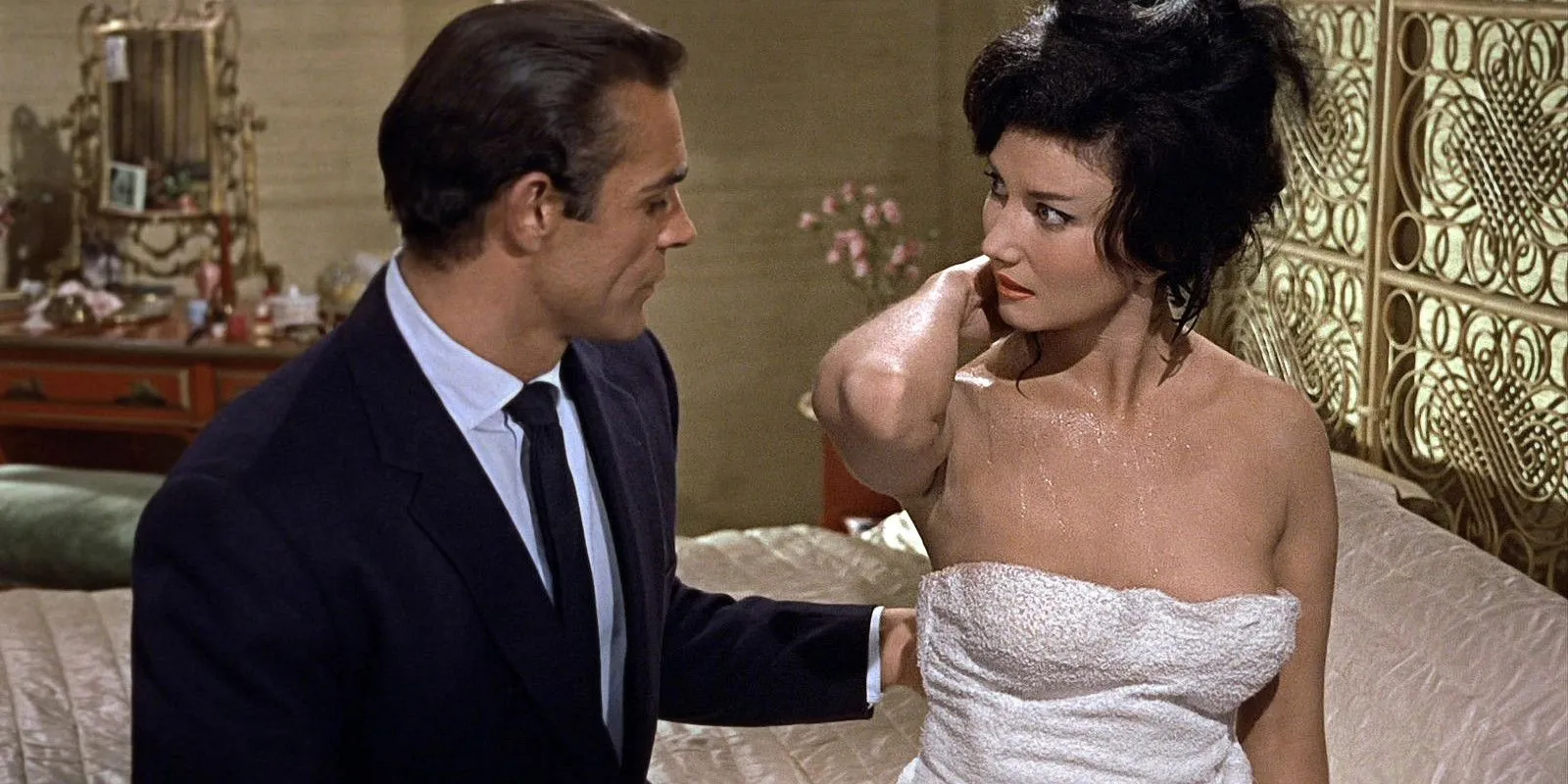 La signorina Taro avvolta in un asciugamano parla con James Bond sul letto in Dr. No.