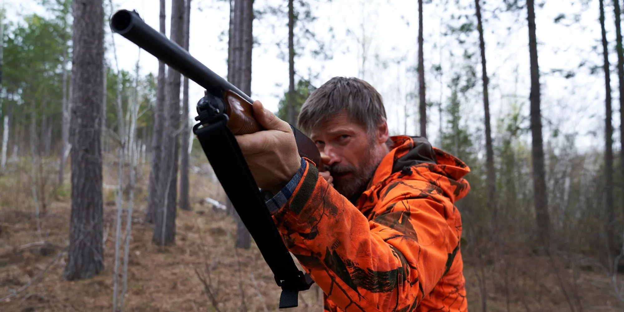 Nikolaj Coster-Waldau as Rayburn holding a hunting rifle in The Silencing.