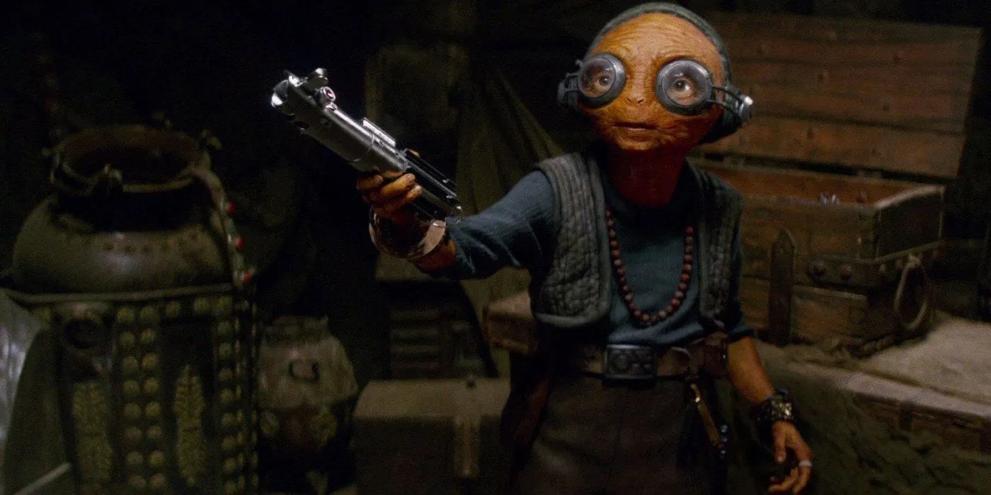 Maz Kanata hält Rey in „Das Erwachen der Macht“ das Lichtschwert von Skywalker hin.