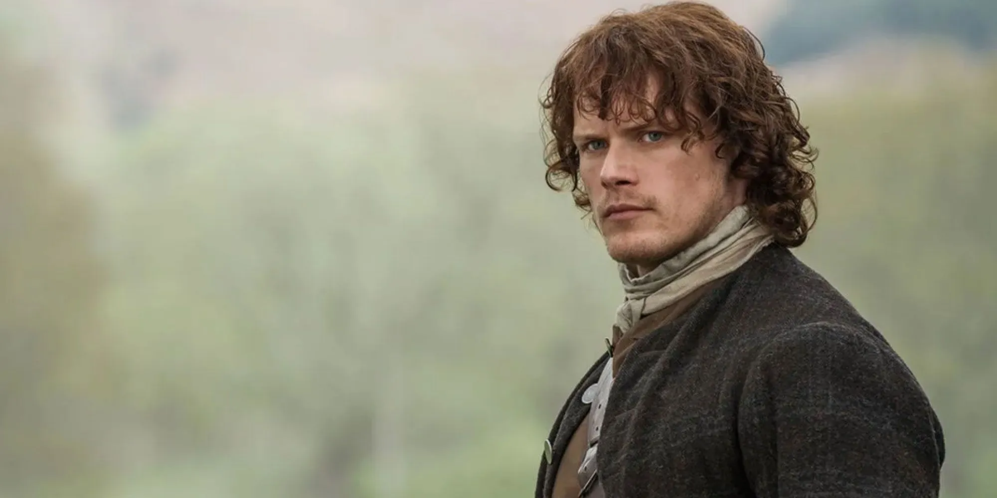 Sam Heughan in a field in Outlander