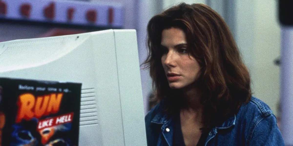 Sandra Bullock mirando una computadora en la red