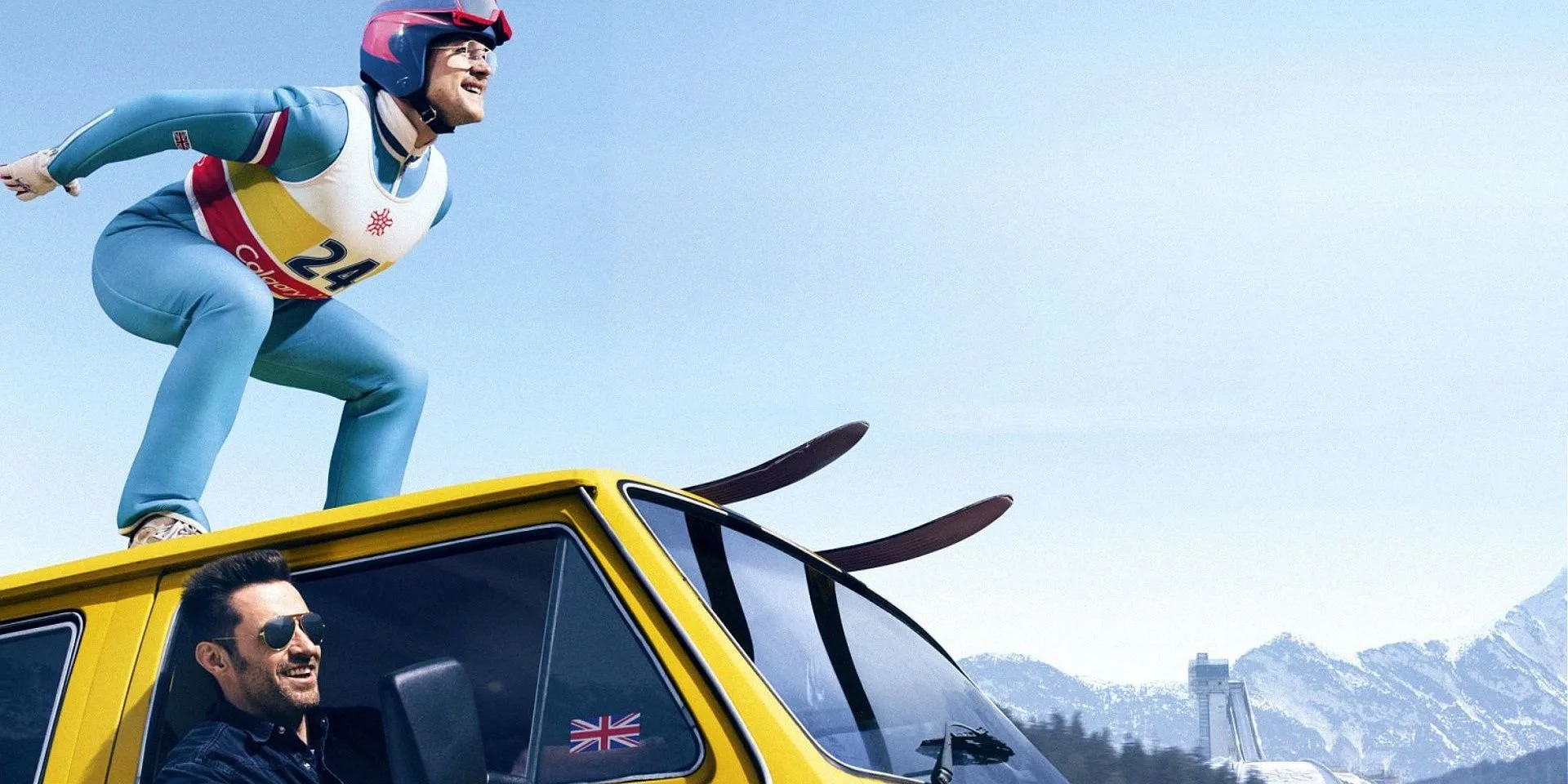 Taron Egerton debout sur une voiture sur des skis dans Eddie The Eagle