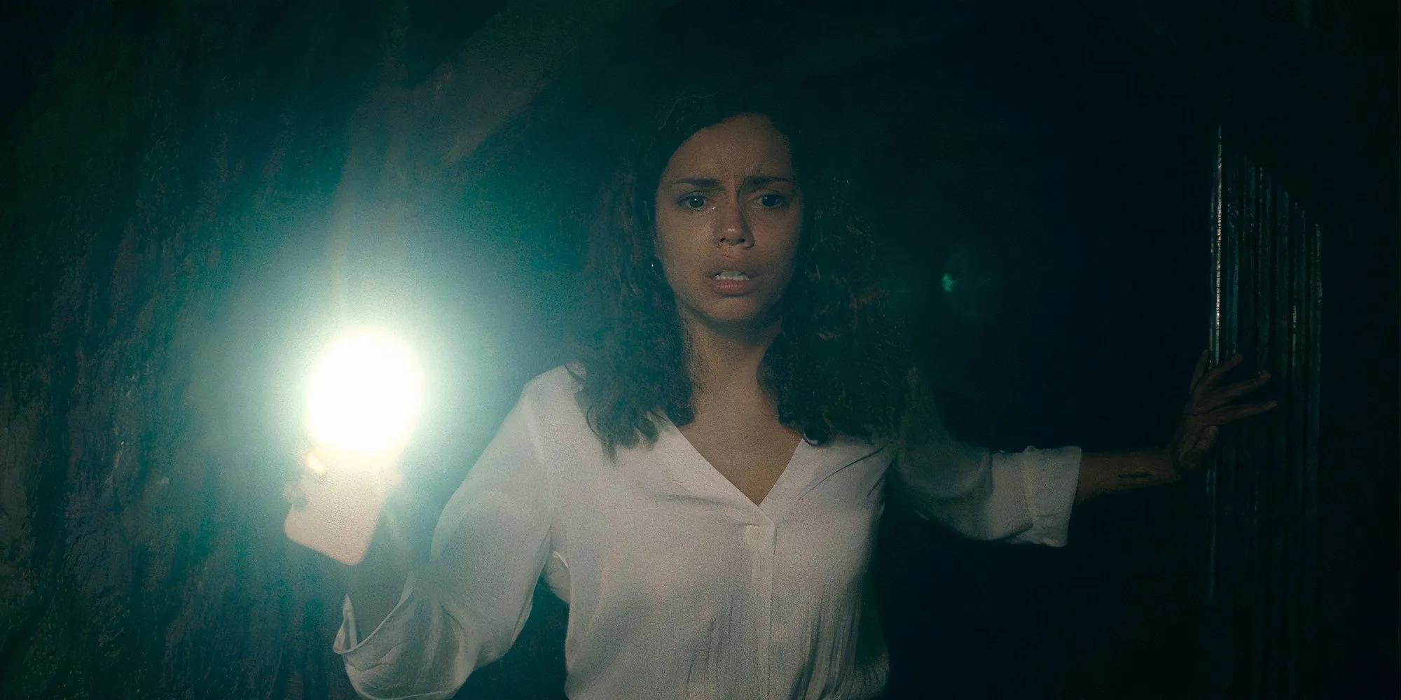 Tess (Georgina Campbell) hält in Barbarian eine Telefon-Taschenlampe hoch