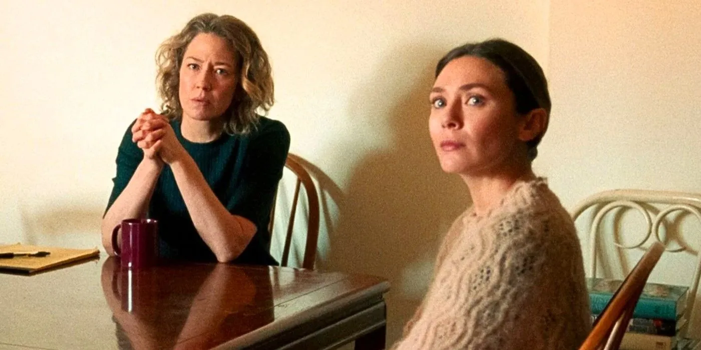 Carrie Coon y Elizabeth Olsen miran algo fuera de cámara mientras están sentadas en la mesa de la cocina en His Three Daughters