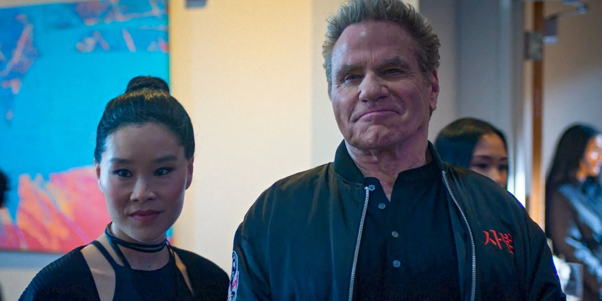 Kim Da-Eun (Alicia Hannah-Kim) i John Kreese (Martin Kove) uśmiechają się w Cobra Kai, sezon 6, odc. 6