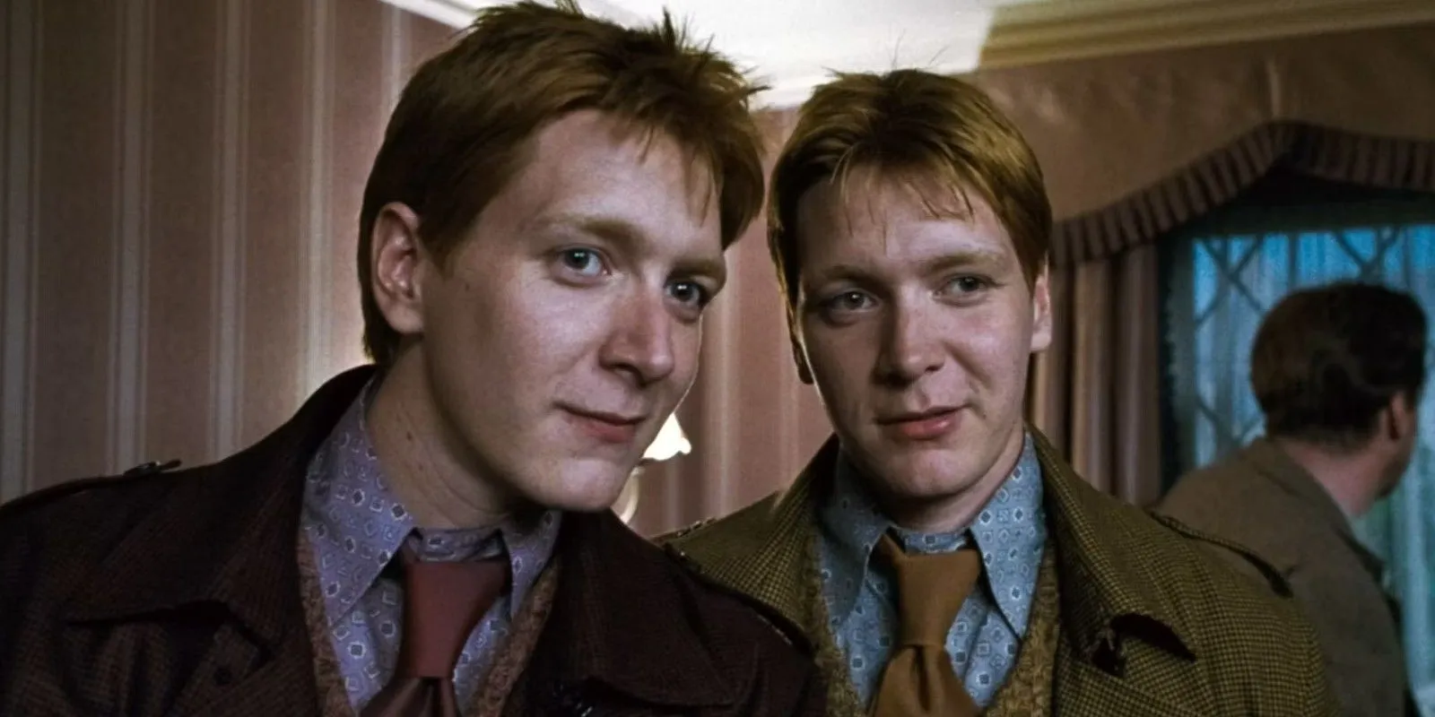 Fred et George Weasley regardent quelqu'un dans Harry Potter et les Reliques de la Mort, partie 1.