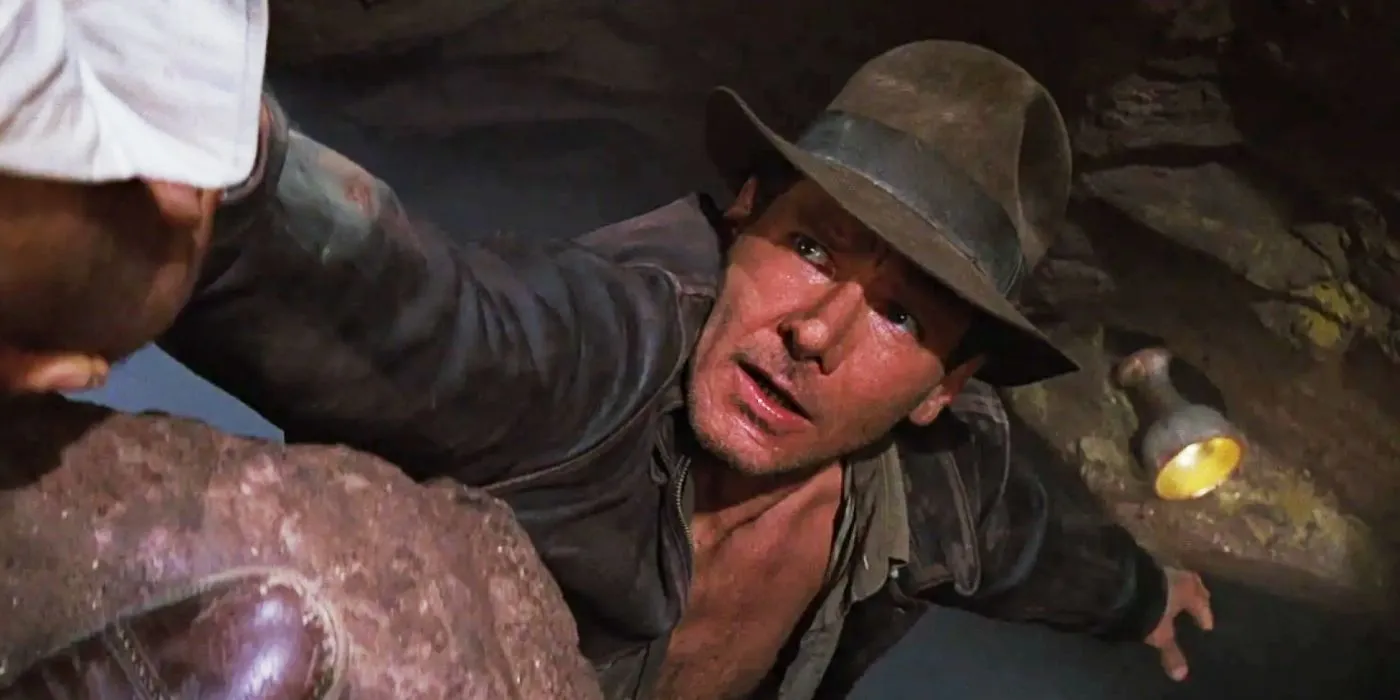 Harrison Ford jako Indy sięgający po Świętego Graala w filmie Indiana Jones i ostatnia krucjata.