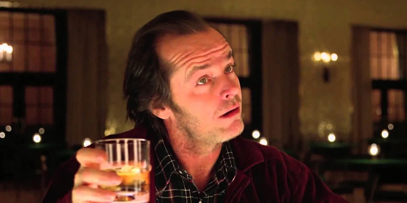 Jack Nicholson dans le rôle de Jack Torrance tenant un verre dans Shining.