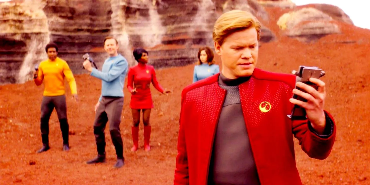 Jesse Plemons als Robert Daly schaut in Black Mirror USS Callister auf seinen Block, während sein Team hinter ihm steht