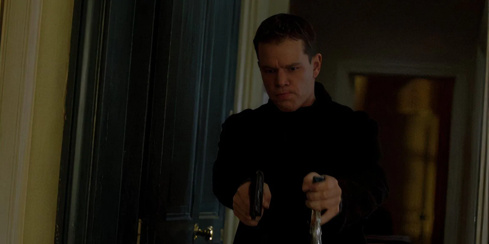 Matt Damon impugna due pistole nei panni di Jason Bourne in The Bourne Identity