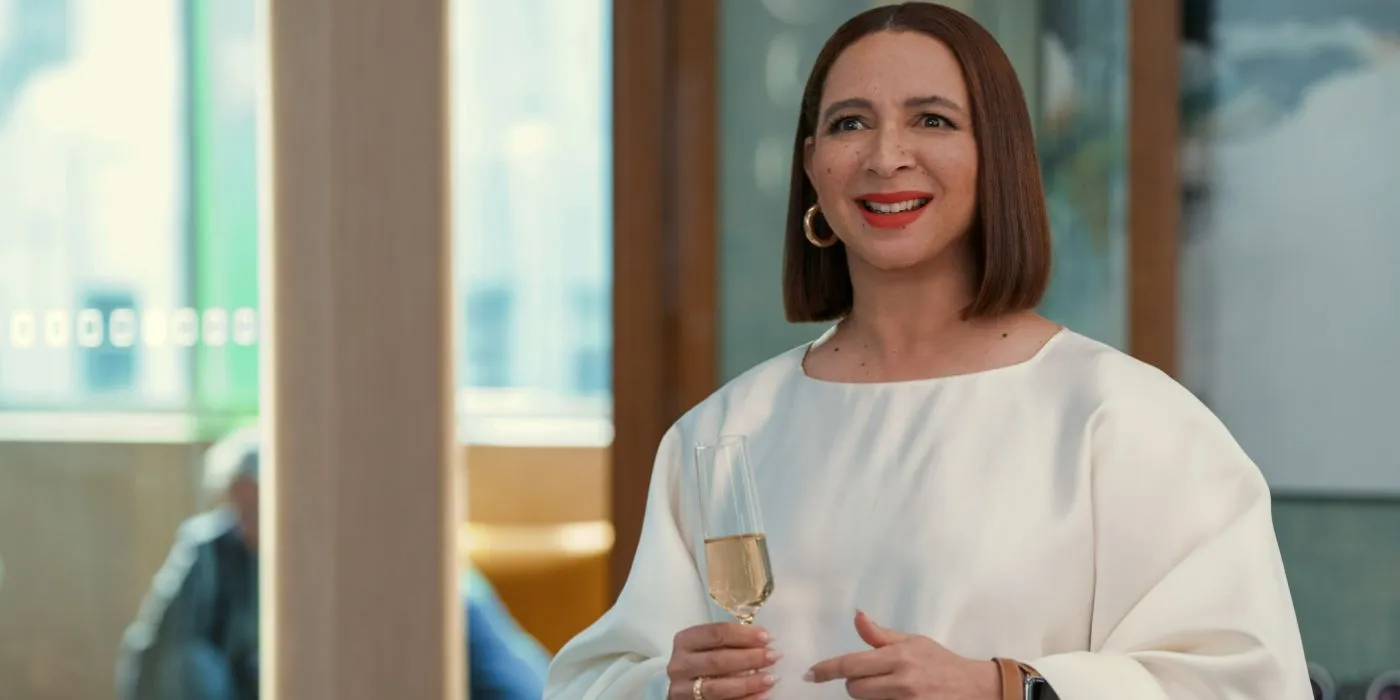 Molly (Maya Rudolph) lacht und hält ein Champagnerglas in der zweiten Staffel von „Loot“.