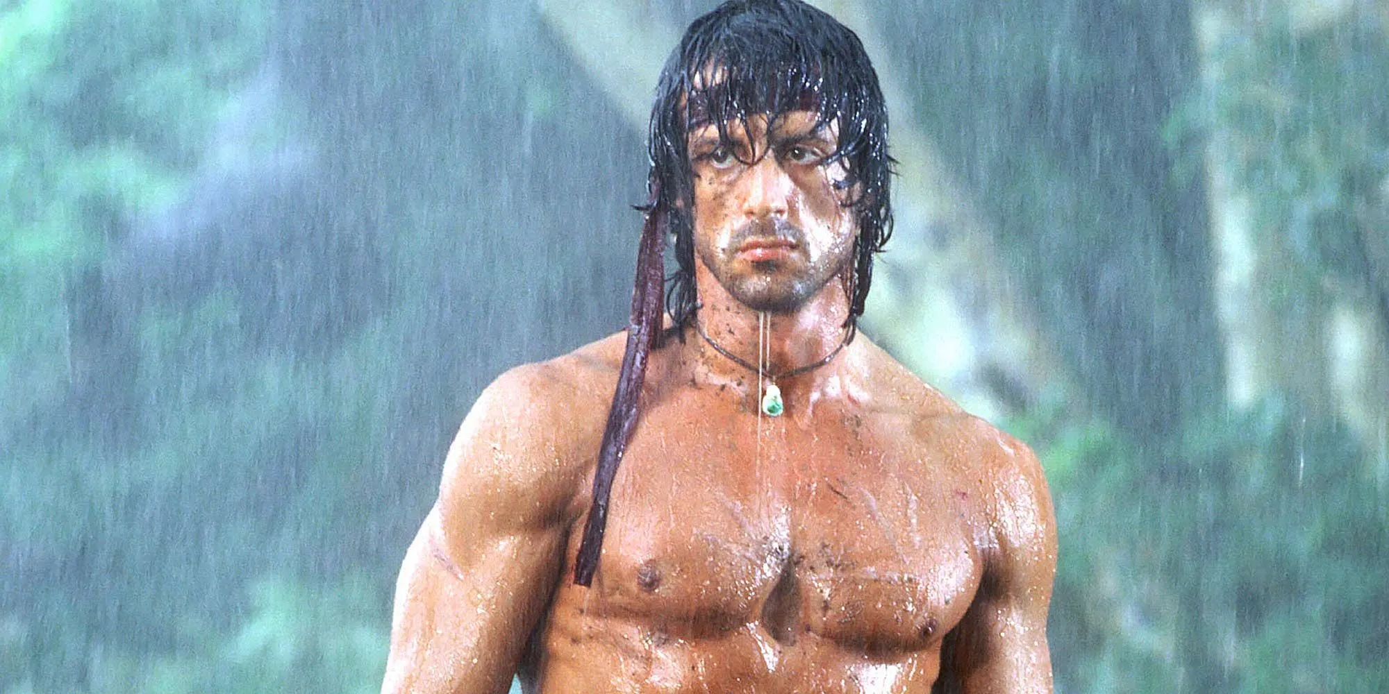 Sylvester Stallone jako John Rambo stojący na deszczu w Rambo: Pierwsza krew, część II