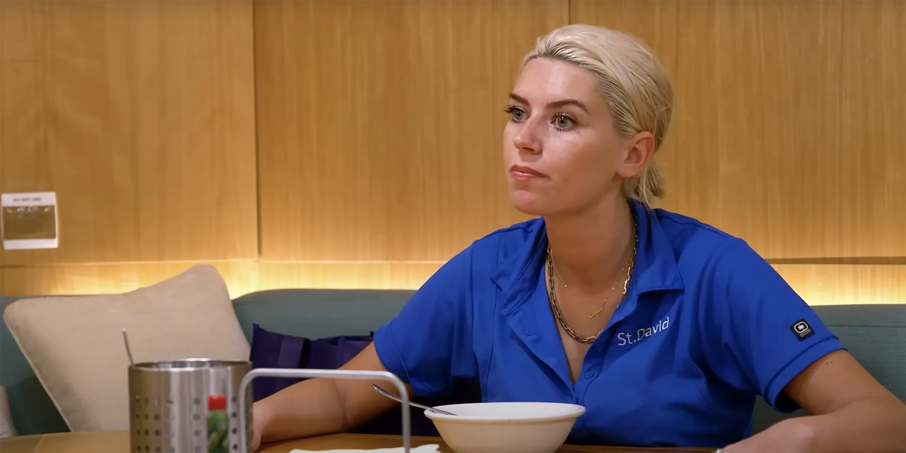 Camille Lamb do Below Deck olhando para longe da câmera em camisa polo azul