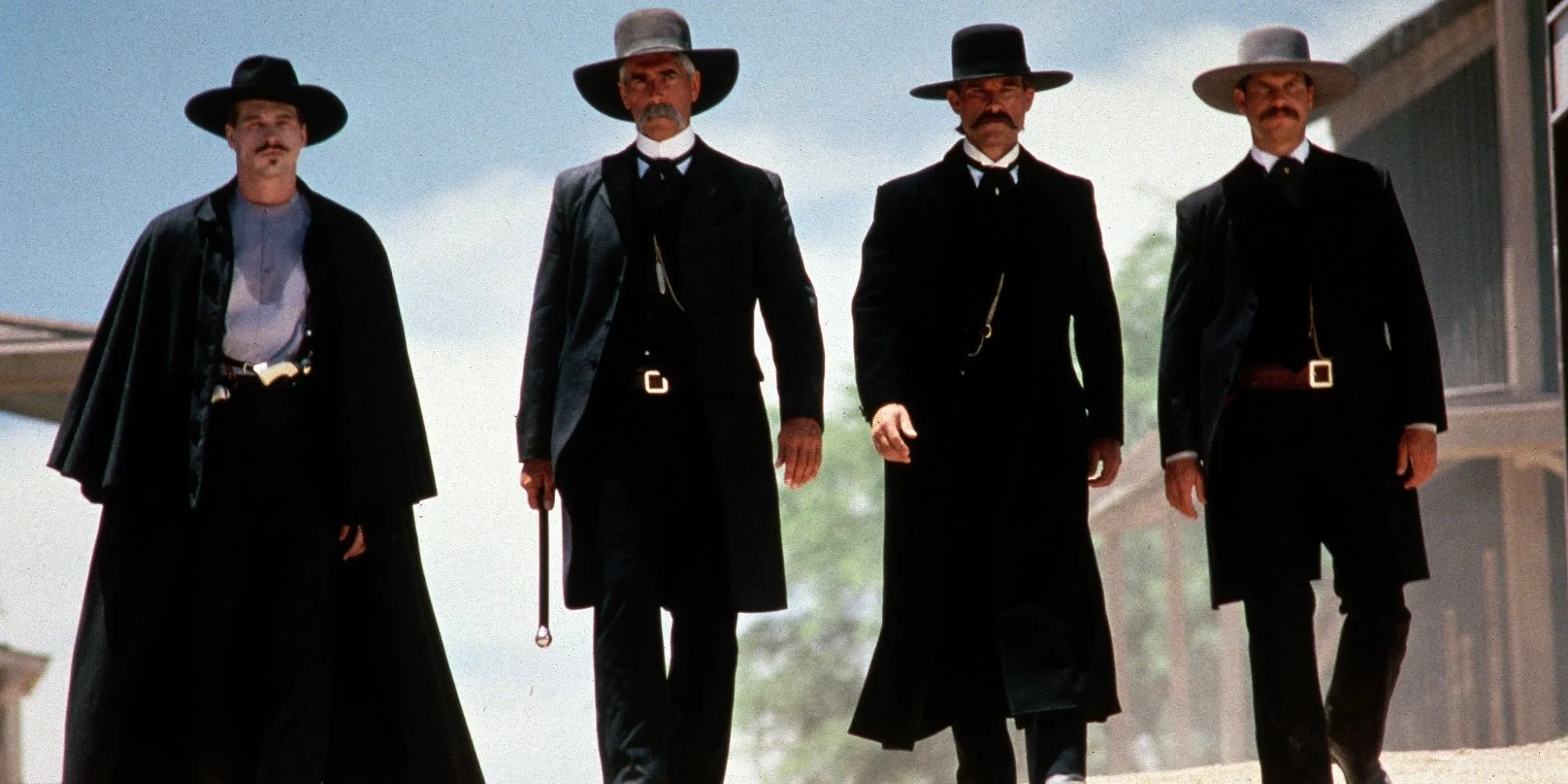 Val Kilmer dans le rôle de Doc Holliday, Sam Elliott dans le rôle de Virgil Earp, Kurt Russell dans le rôle de Wyatt Earp et Bill Paxton dans le rôle de Morgan Earp alors qu'ils se promènent en ville à Tombstone.