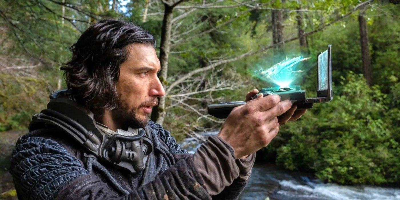 Adam Driver sosteniendo un dispositivo tecnológico en 65