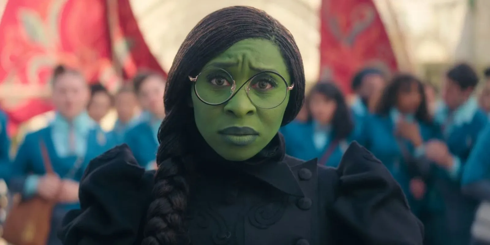 Cynthia Erivo como Elphaba en la Ciudad Esmeralda, luciendo preocupada.