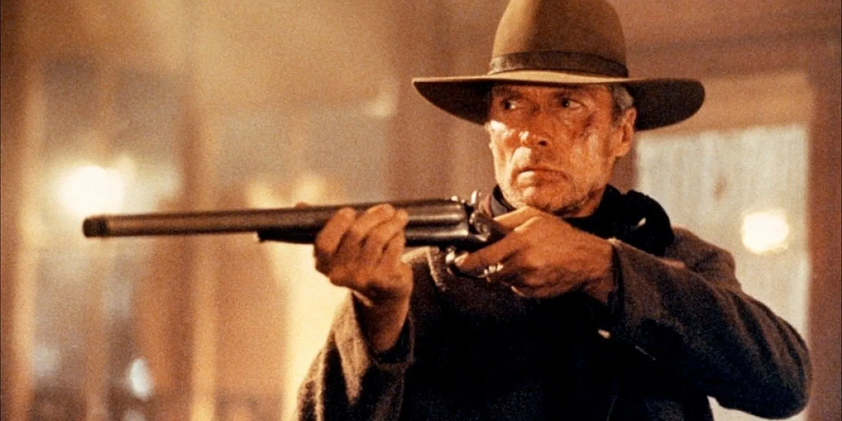 Clint Eastwood als Will Munny, der in „Erbarmungslos“ ein Gewehr hochhält